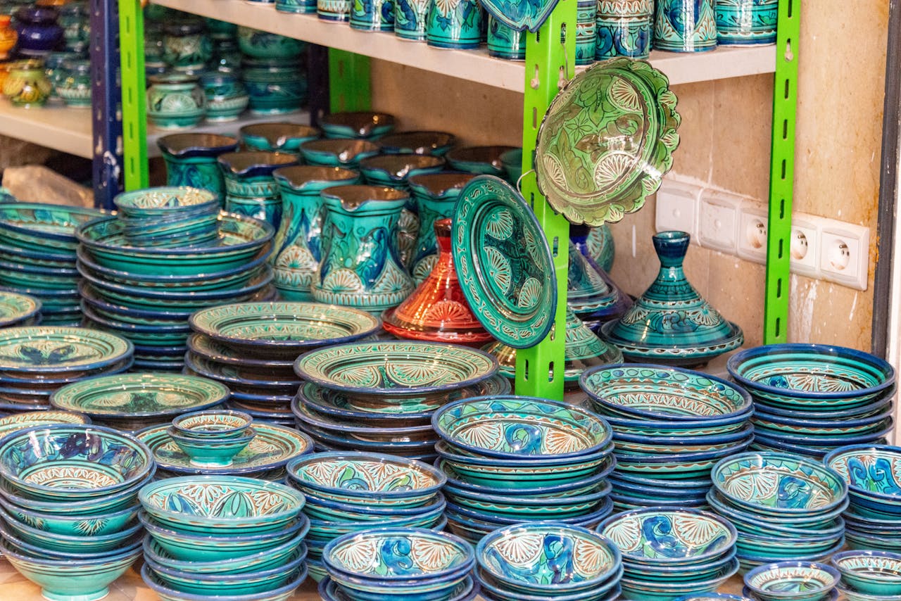 Colorful handmade ceramic dinnerware on display in a shop with intricate patterns.